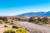 View of a road passing through agricultural field to a mountain