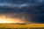 Stormy sky over a farm field at sunset