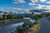 Butte and river under dramatic clouds with distance mountains an